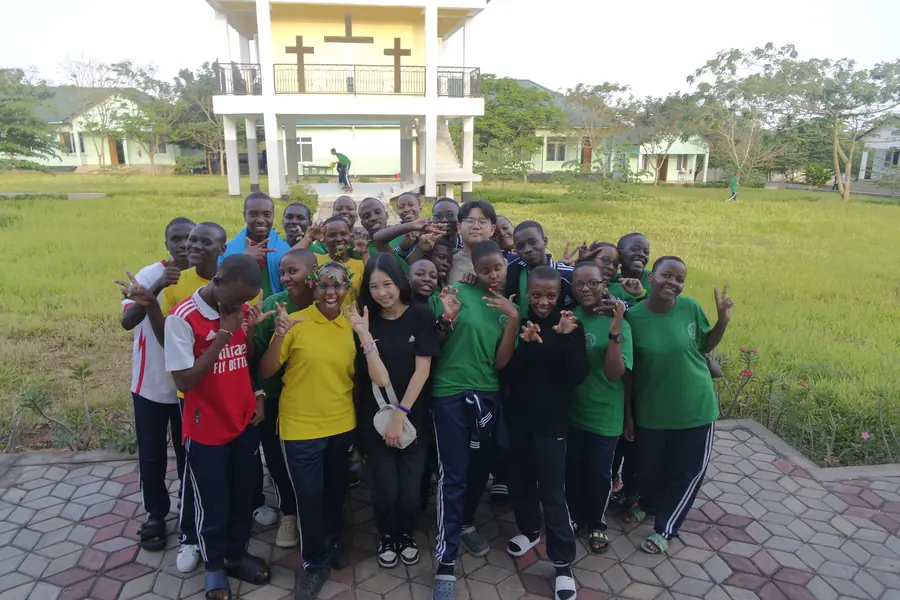 Korrine in a large group of students on a lawn in front of a building