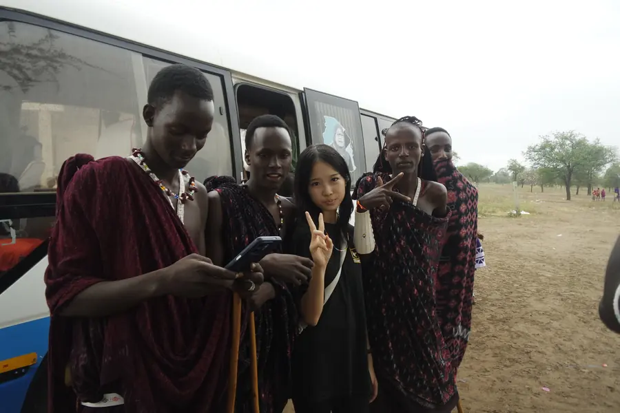 Korrine with Maasai men beside a bus