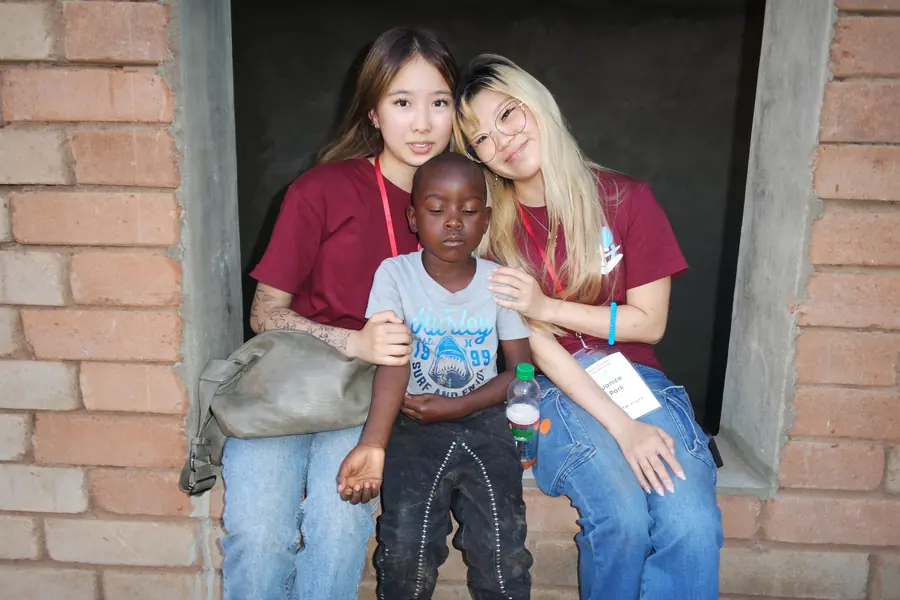 Korrine and another volunteer sitting with a young boy