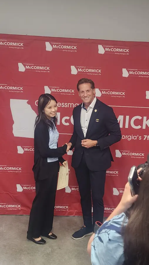 Korrine with Congressman Rich McCormick in front of a campaign backdrop