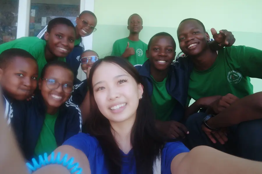 A selfie of Korrine with students in green school shirts